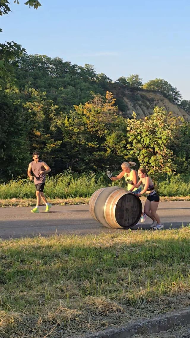 Two athletes training with a Bravio delle Botti barrel near Montepulciano